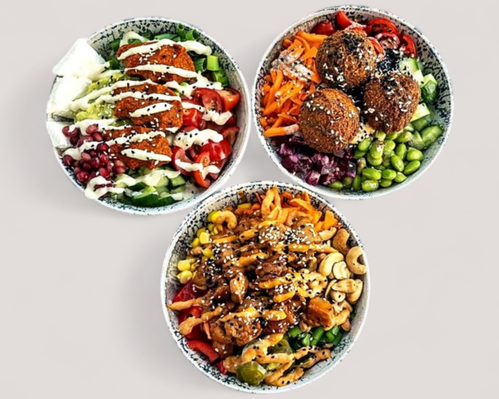 Drei bunte Bowls mit Falafel Cashewkernen und Gemüse für Mittagstisch im Cafe Köln Zollstock